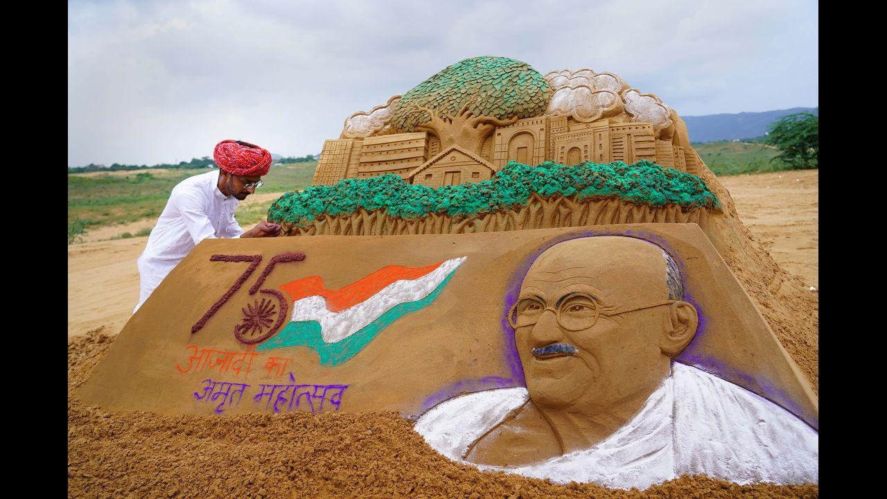 Artist Ajay Rawat creates a sand art of Mahatma Gandhi on the eve of his birth anniversary, in Pushkar. Pic/PTI